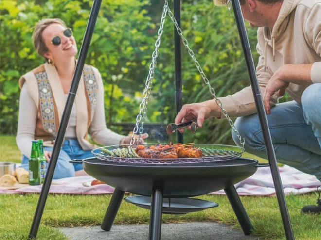 Duży kominek ogrodowy stojący na trójnogu z rusztem zawieszanym grill węglowy